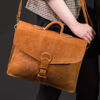 Light Brown Large Marrakech Satchel Held by Person in Chequered Coat on Black Background