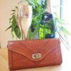 Light Brown Leather Purse with Champagne Flutes, Bottle of Champagne and a Plant