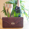 Dark Brown Leather Purse with Champagne Flutes, Bottle of Champagne and a Plant
