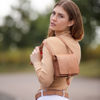 A brown haired model holding a square saddle bag over her shoulder